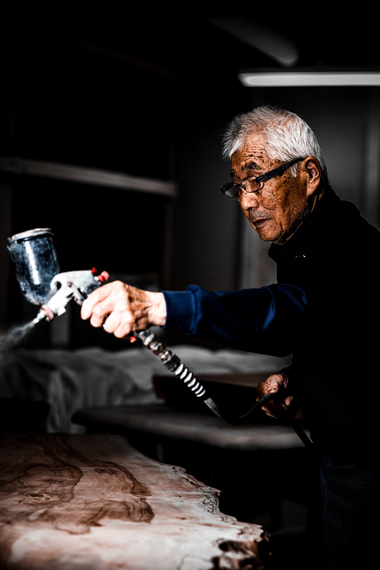 一枚板を仕上げる職人の手