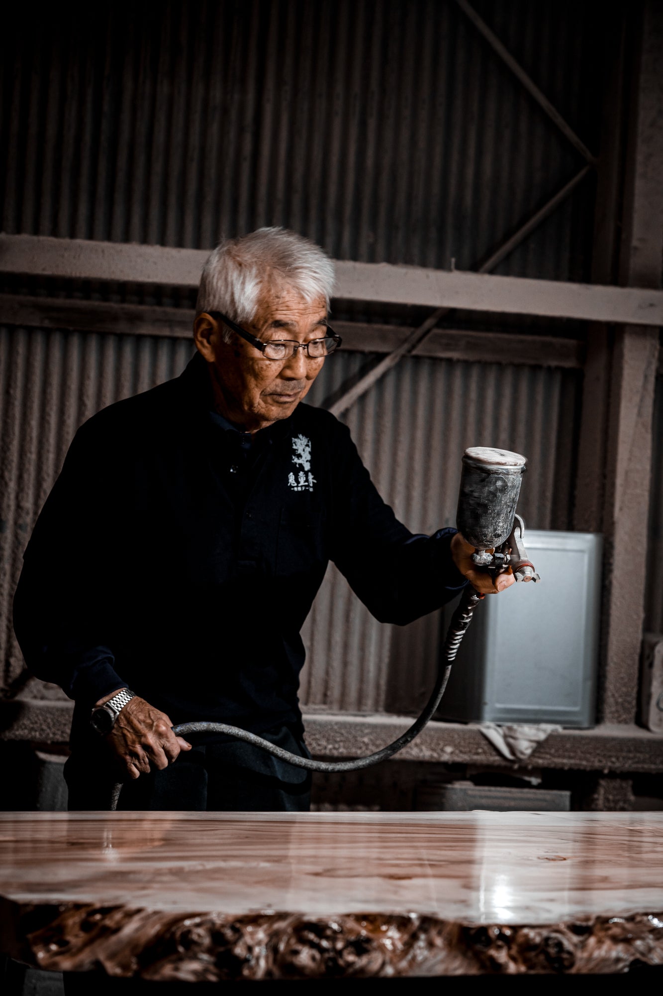 一枚板を仕上げる職人の手